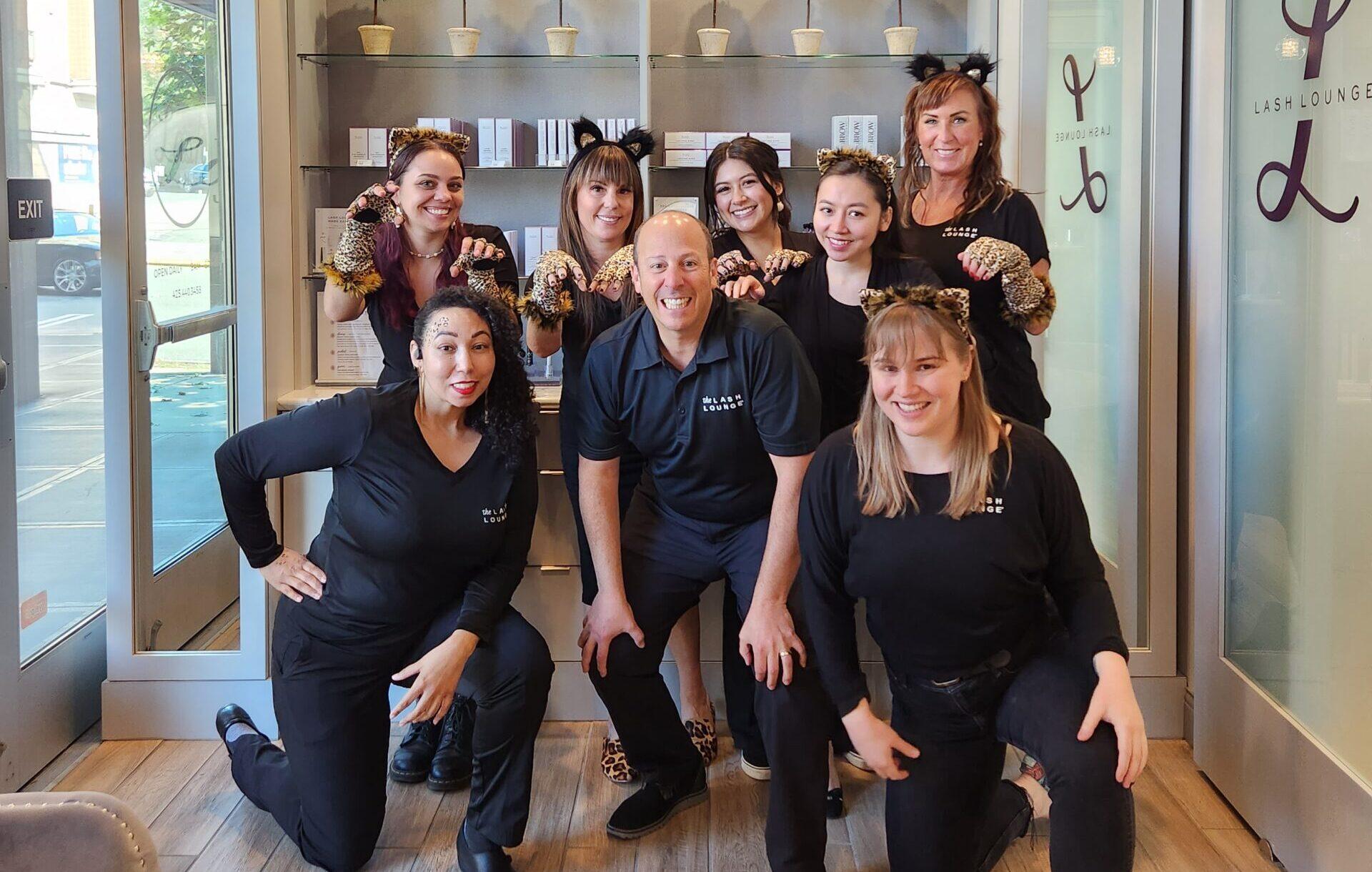 A group of business owners smiling together inside The Lash Lounge franchise.