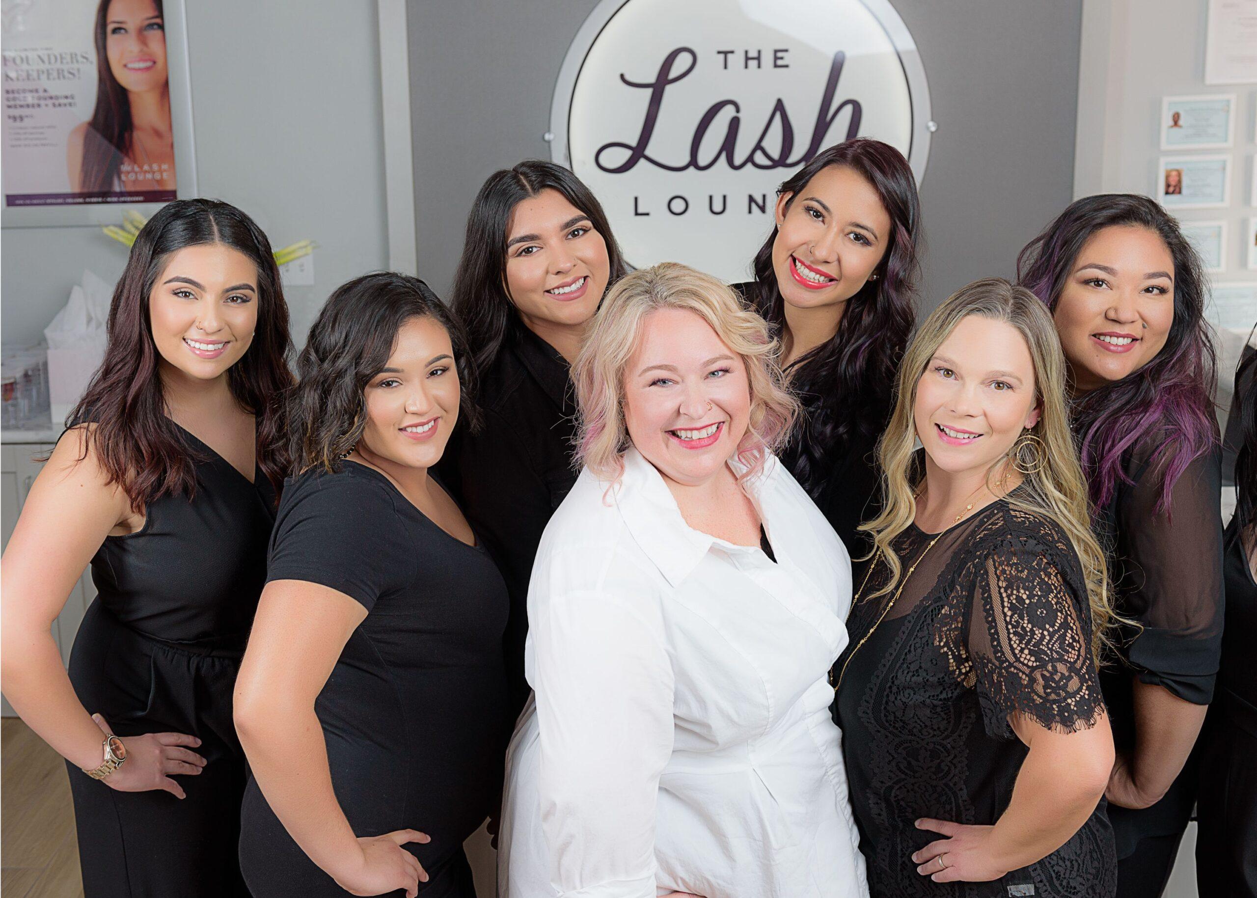 A group of eyelash business owners posing in front of The Lash Lounge franchise.