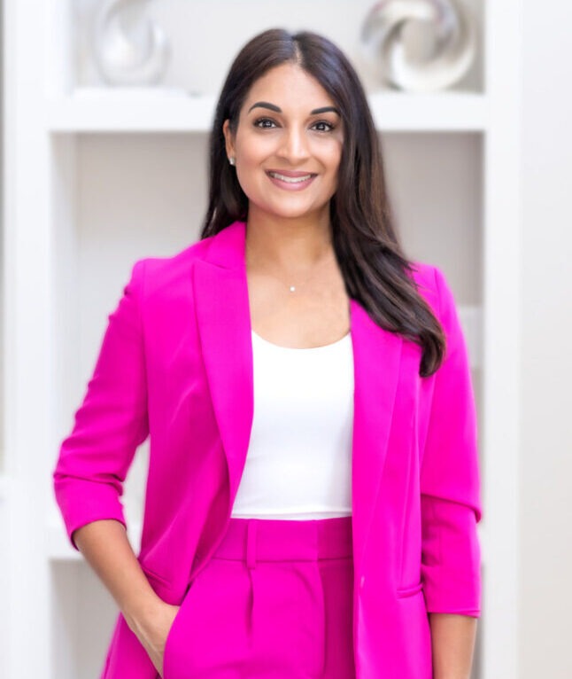 Reena Patel of The Lash Lounge franchise standing in a pink outfit.